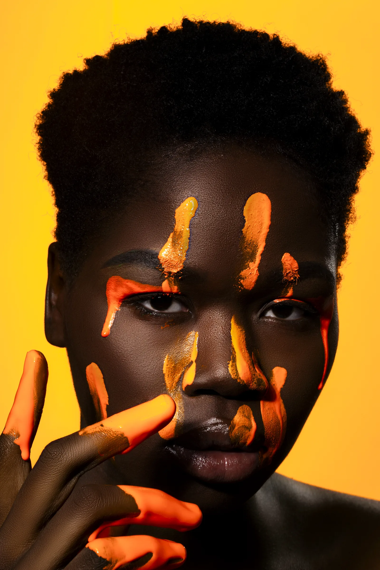 Editorial model portrait with orange body paint after professional retouching