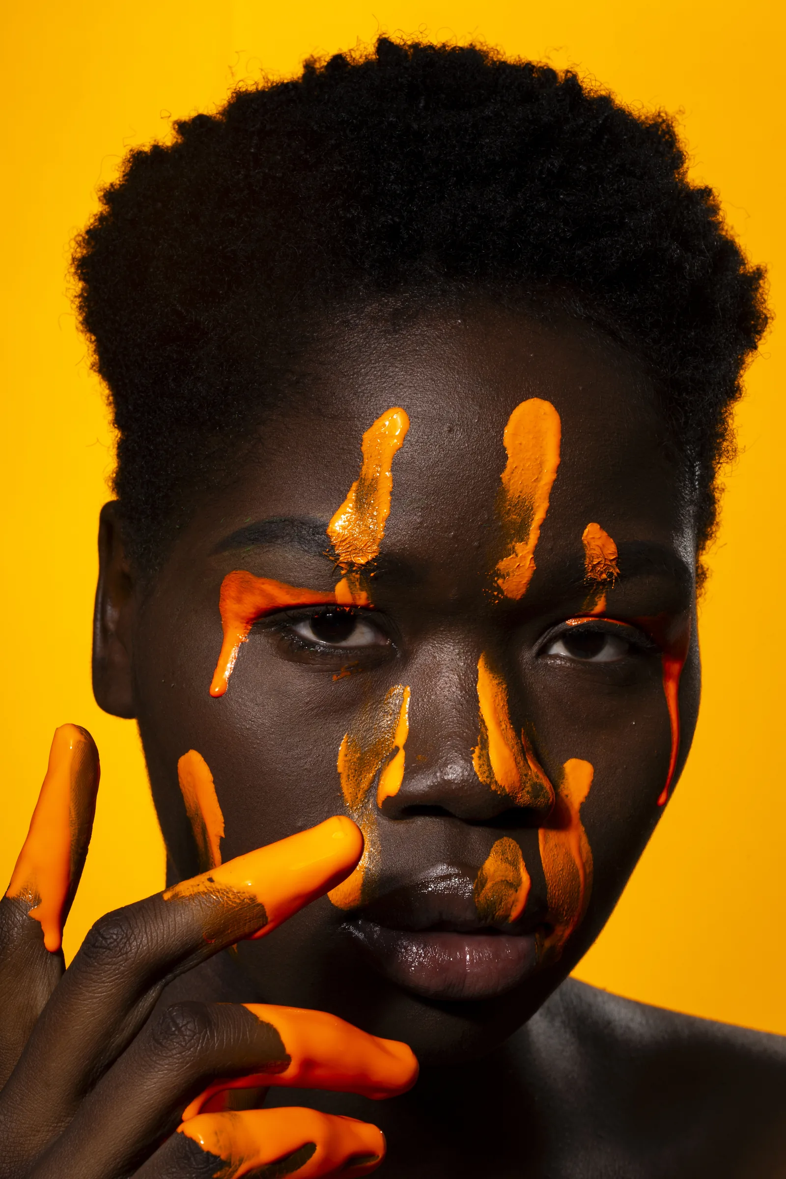 Editorial model portrait with orange body paint before retouching